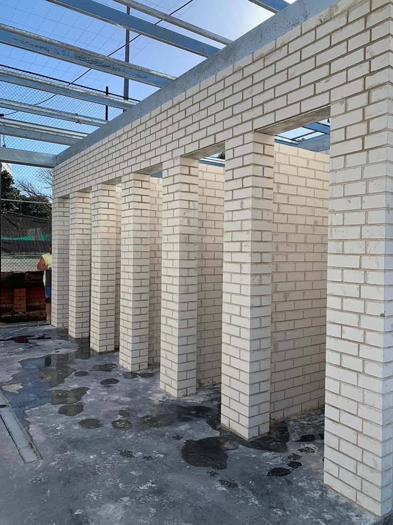 Light coloured brickwork and piers with recessed openings