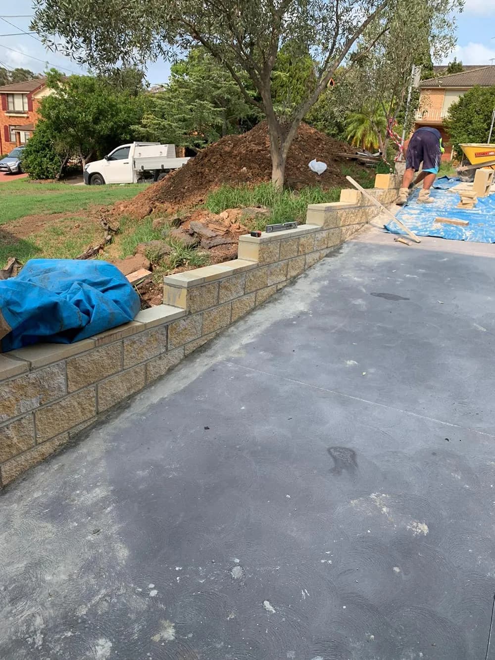 Garden retaining wall beside a paved driveway during construction