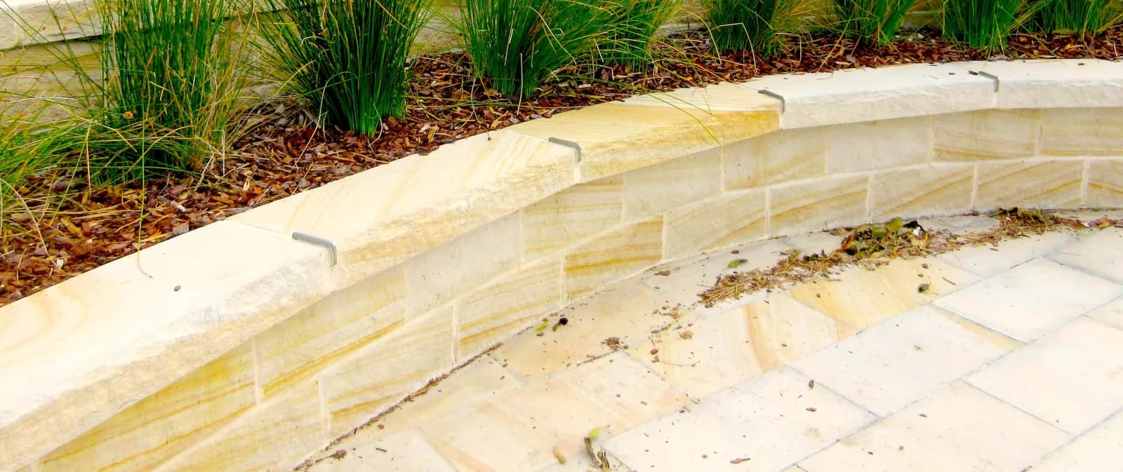 Curved sandstone retaining wall garden bed