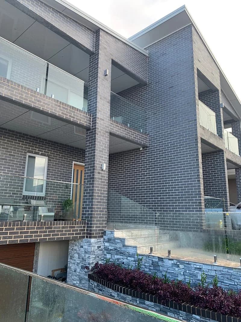 Modern dark brick townhouse glass balconies