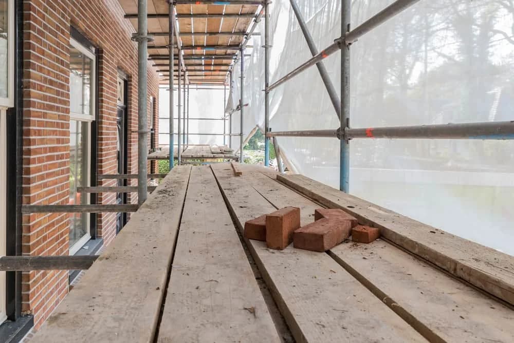 Scaffolding walkway beside brick building